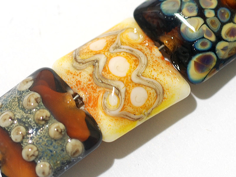 11201504C - Seven Dark Yellow w/Silver Stringers Pillow Beads