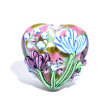 Heart-shaped glass ornament with floral designs on a white background