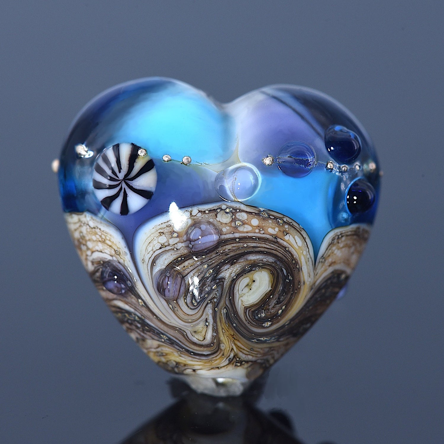 Heart-shaped glass object with swirling patterns on a dark background