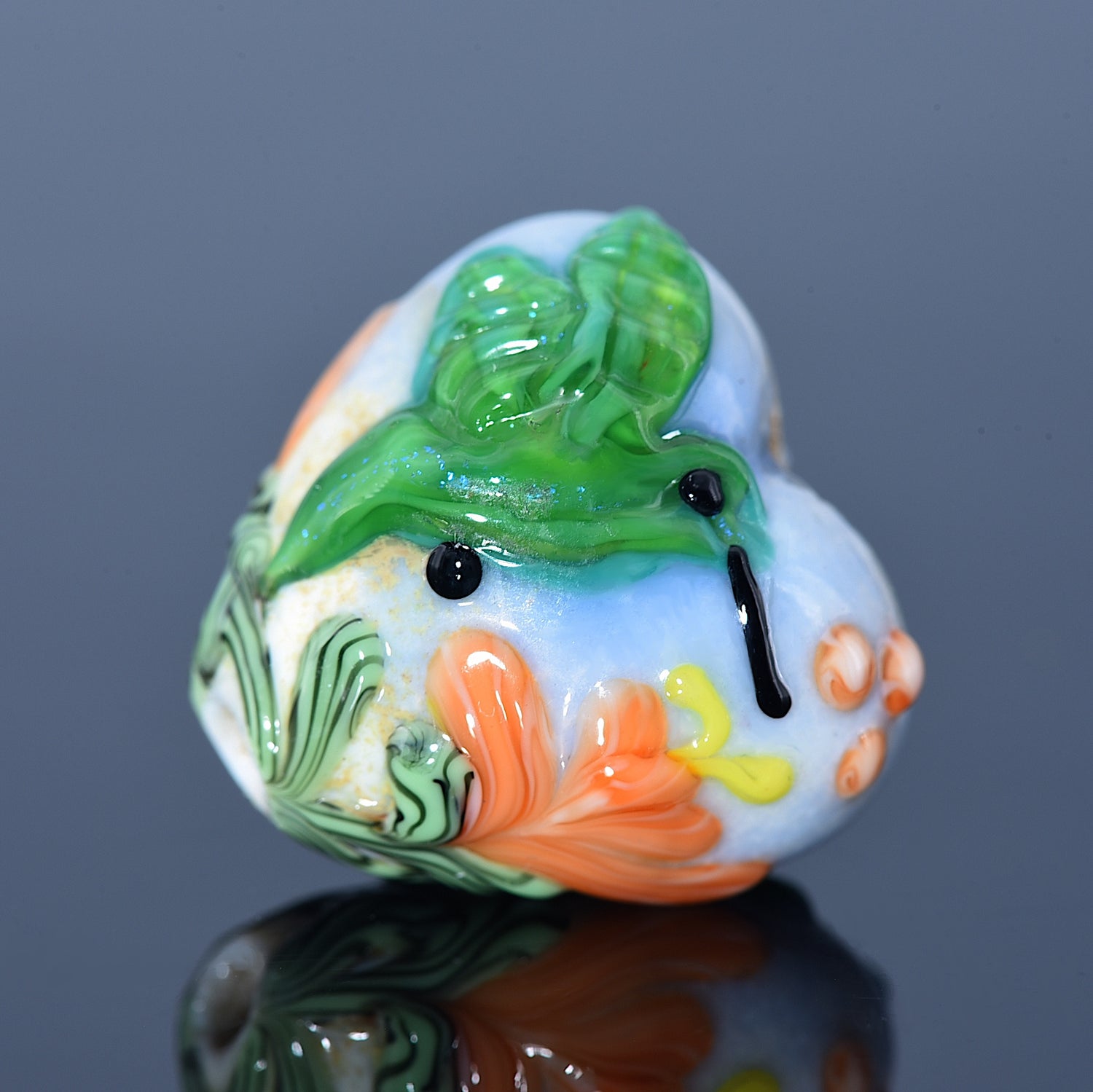 Decorative glass piece with floral design on a reflective surface