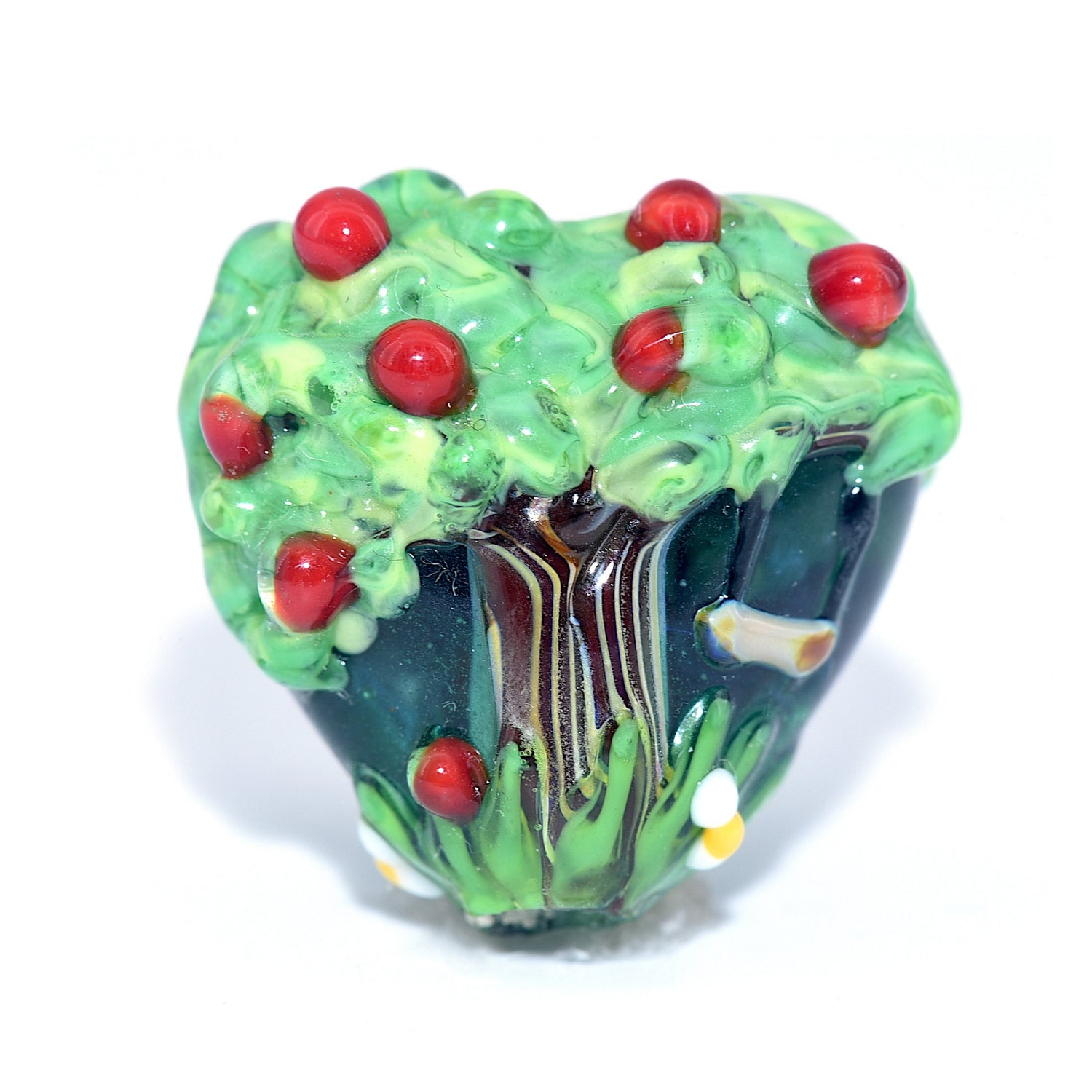Glass bead with tree design and red berries on a white background
