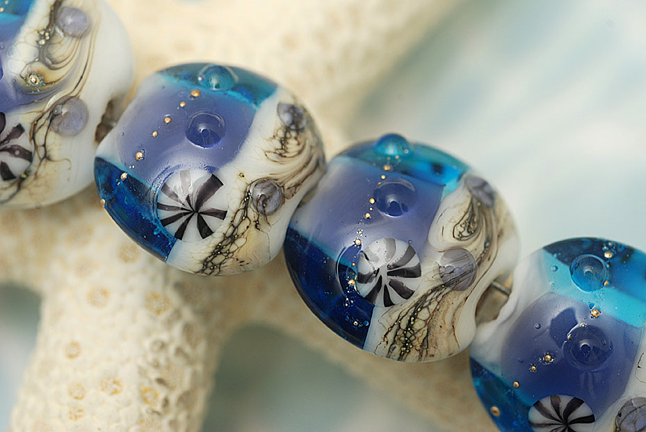 10407112 - Four Transparent Blue Seashell Lentil Beads