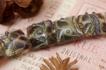 10407304 - Seven Black w/Purple Silver Foil Pillow Beads