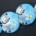 Blue flower-shaped objects with yellow centers on a dark background