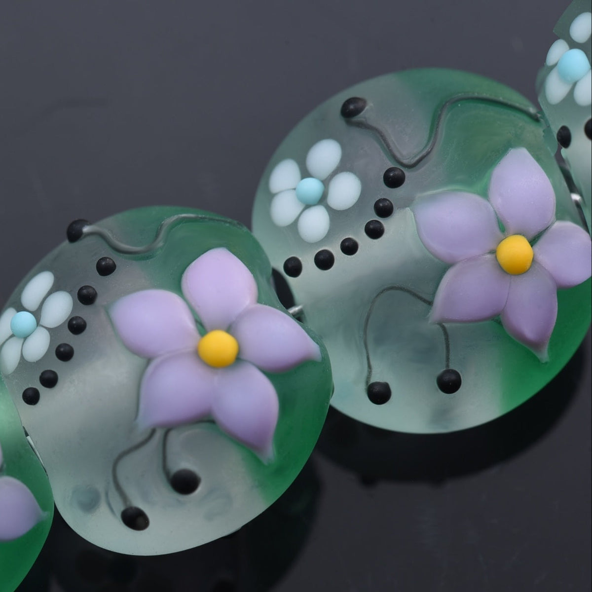 Decorative buttons with floral designs on a dark background