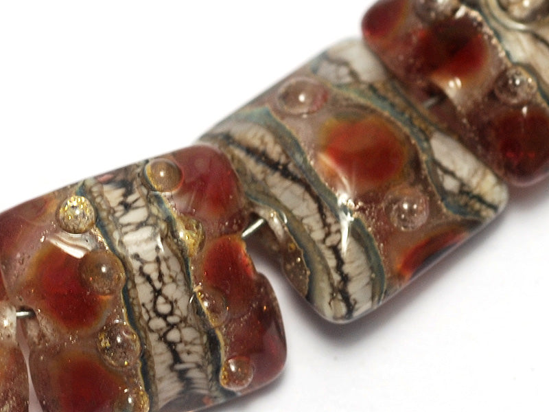 10703804 - Seven Transparent Red w/Silver Foil Pillow Beads