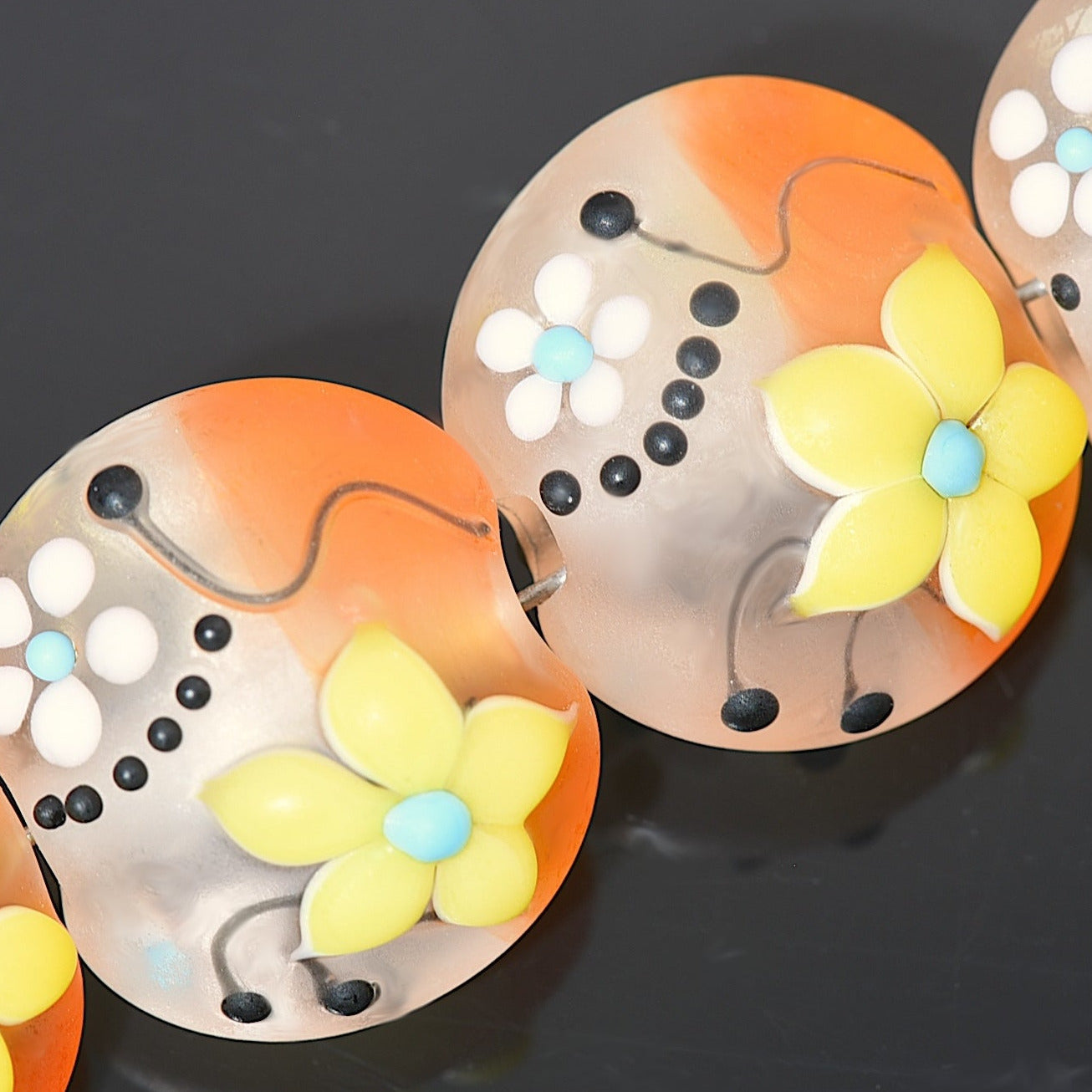 Decorative buttons with floral designs on a dark background