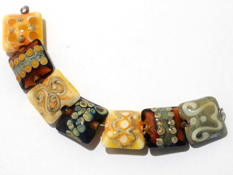 11201504C - Seven Dark Yellow w/Silver Stringers Pillow Beads
