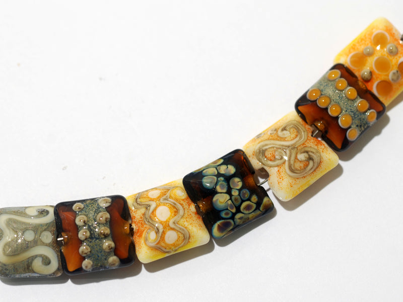 11201504C - Seven Dark Yellow w/Silver Stringers Pillow Beads