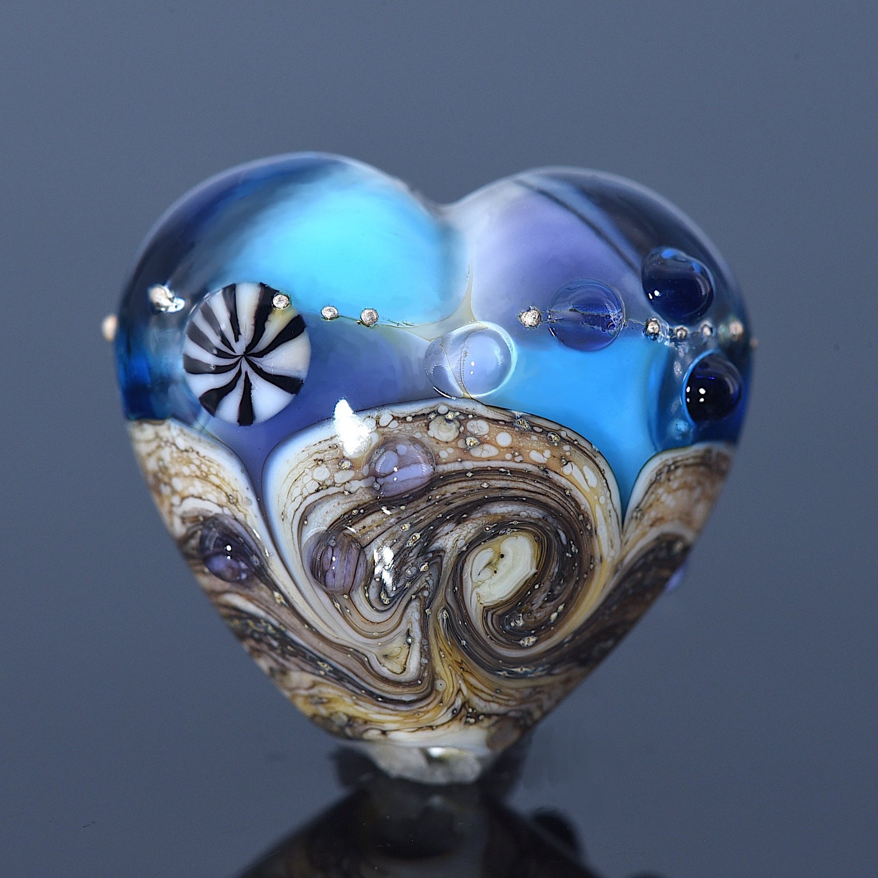 Heart-shaped glass object with swirling patterns on a dark background