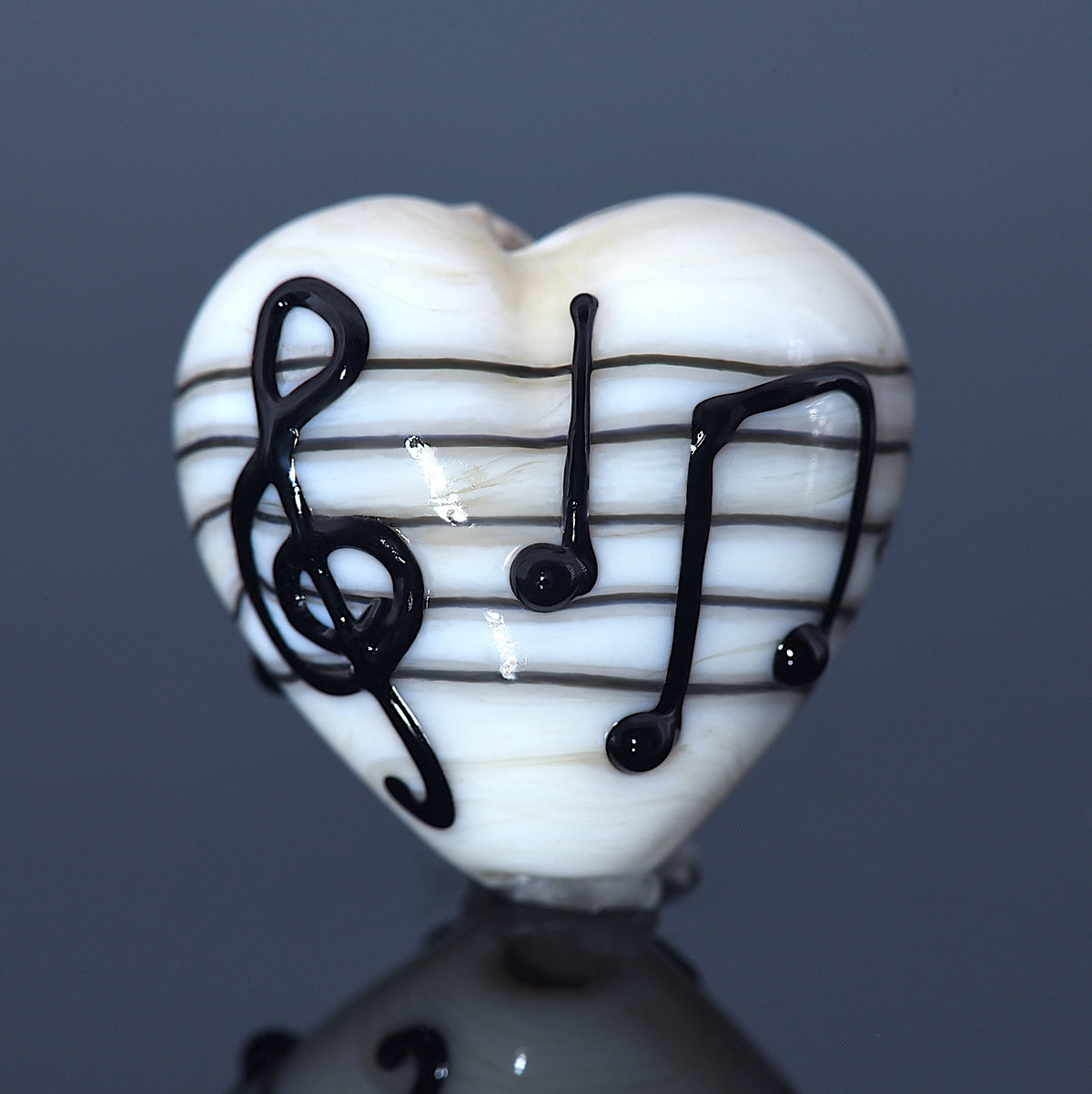 Heart-shaped object with musical notes on a reflective surface