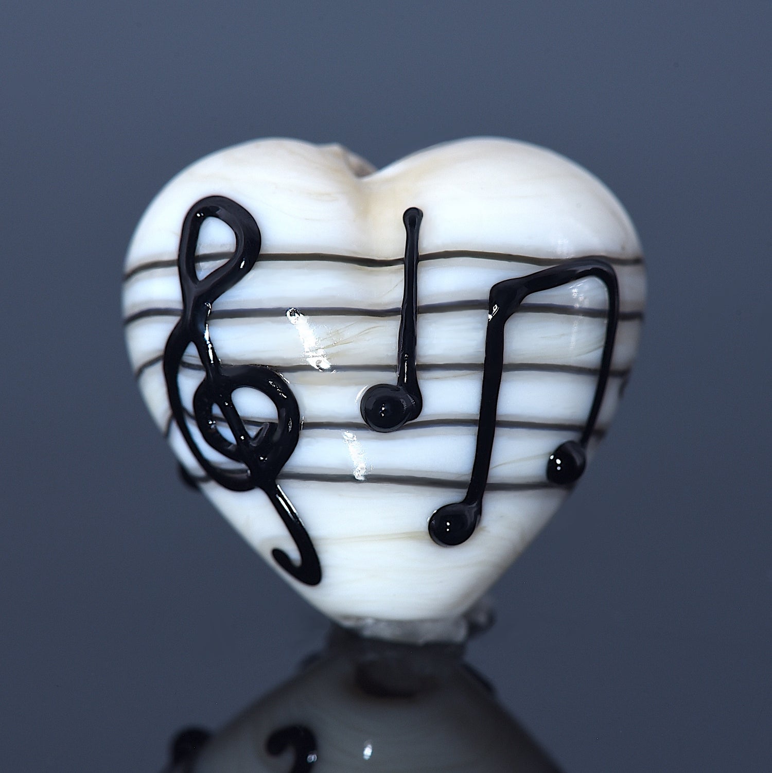 Heart-shaped object with musical notes on a reflective surface