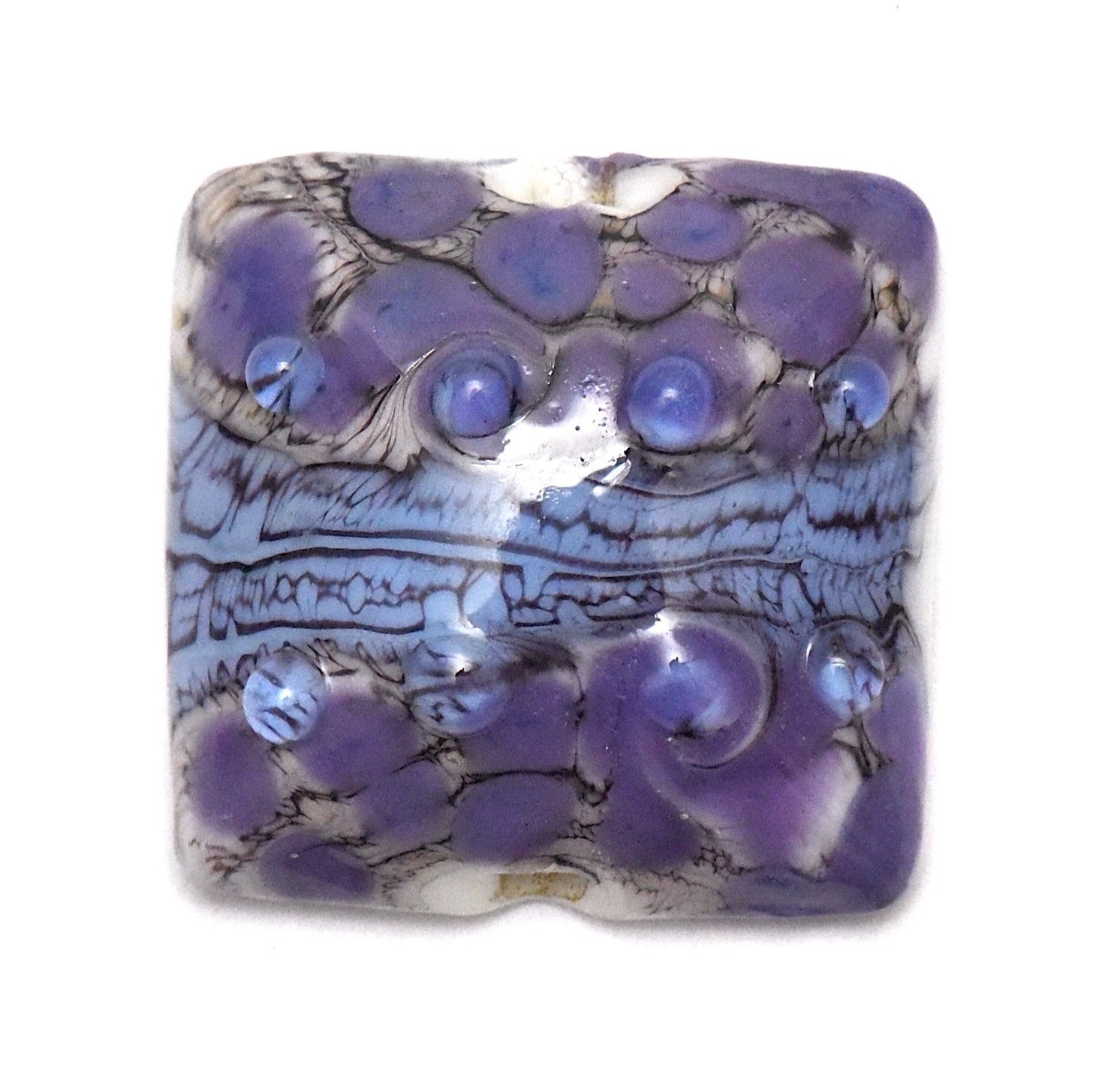 Decorative purple stone with intricate patterns on a white background