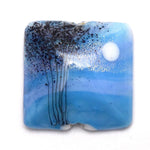 Square glass pendant with blue and black design on a white background