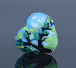 Glass bead with tree design on a reflective surface