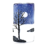 Glass bead with winter scene design featuring a tree, moon, and snowflakes on a white background.