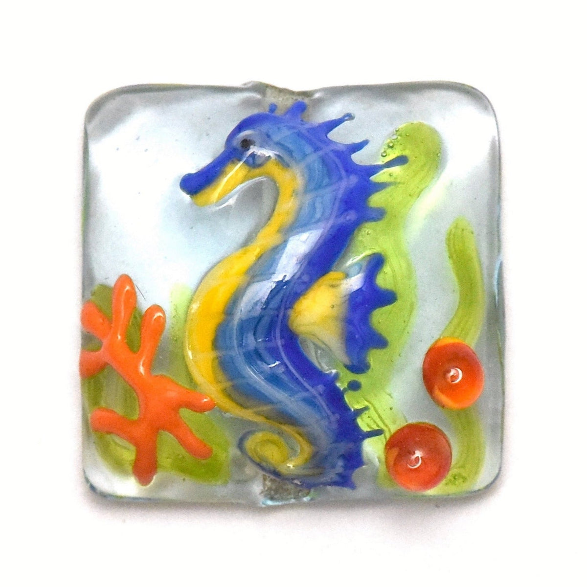 Colorful glass seahorse with coral on a white background