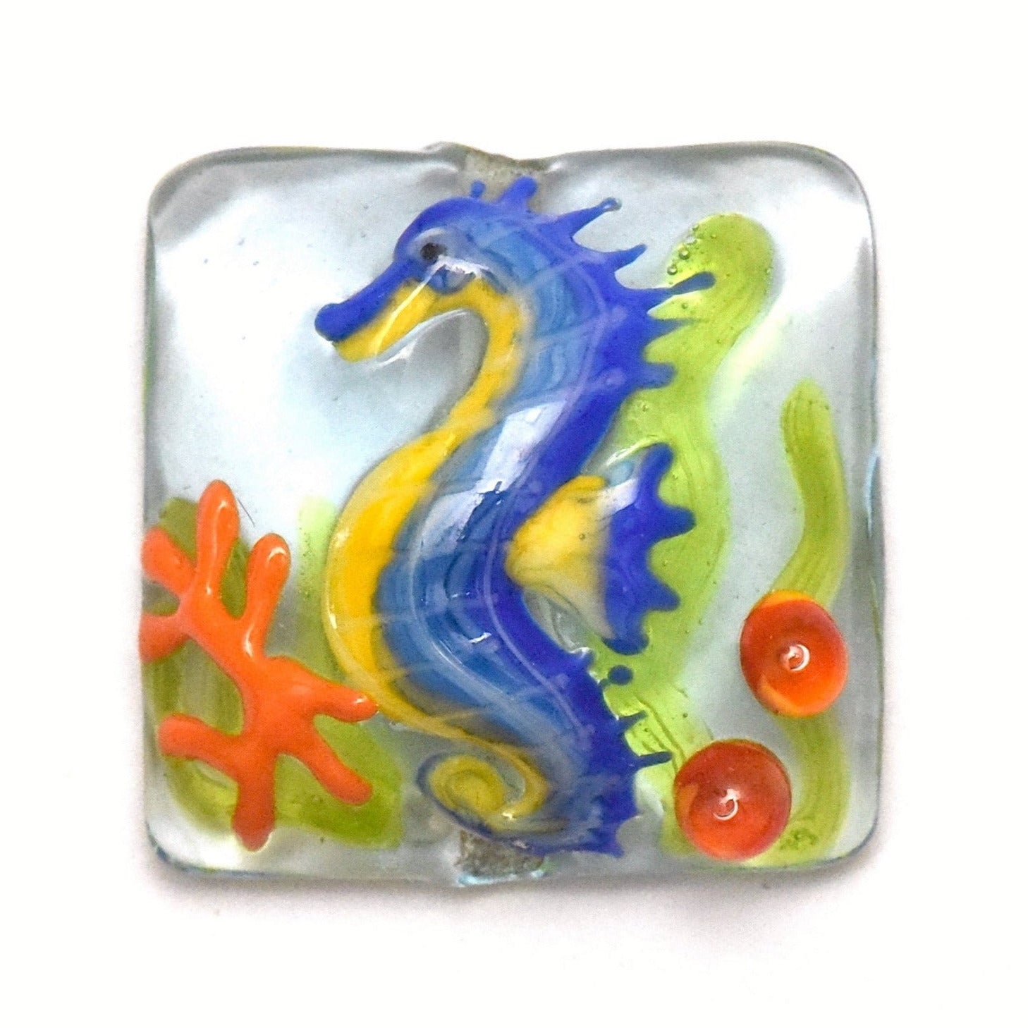 Colorful glass seahorse with coral on a white background